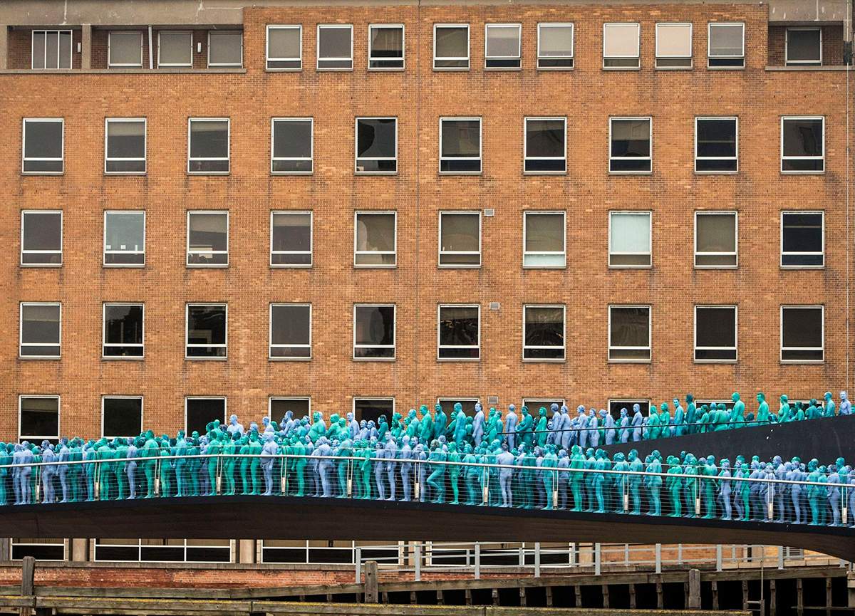People stand on the Scale Lane Swing Bridge taking part in a mass nude art installation entitled Sea of Hull by New York based artist Spencer Tunick in Hull, England, Saturday July 9, 2016. 