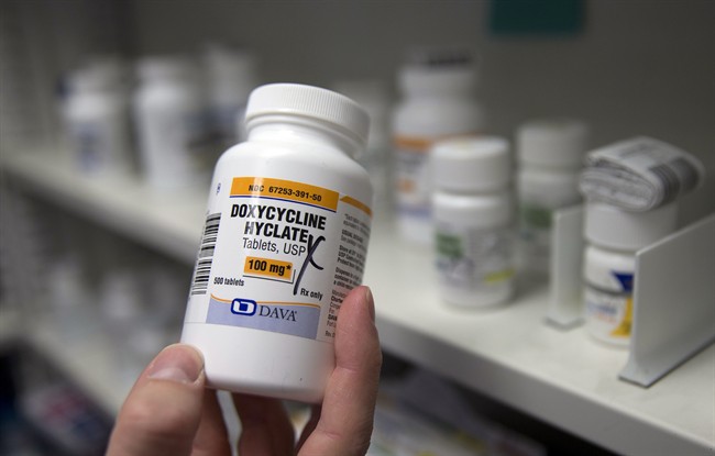 In this Friday, July 8, 2016, photo, pharmacist Clint Hopkins, owner of Pucci's Pharmacy, displays a bottle of the antibiotic doxycycline hyclate, in Sacramento, Calif. The drug is one of several that has seen a significant cost increase in recent months.