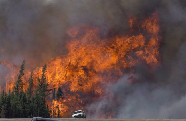 A giant fireball is seen as a wildfire rips through the forest 16 kilometres south of Fort McMurray, Alta. on Highway 63 Saturday, May 7, 2016. 