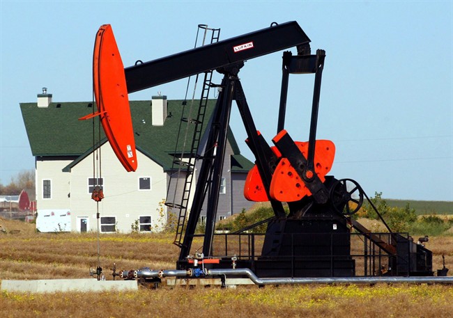 A pump jack dwarfs a house northwest of Calgary, in this Sept. 28, 2004 photo. 