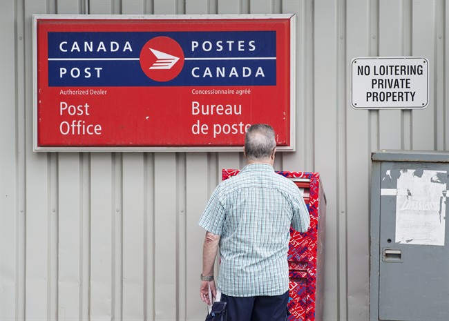A man mails a letter outside a Canada Post office in Halifax on Wednesday, July 6, 2016. Darren Calabrese/The Canadian Press.