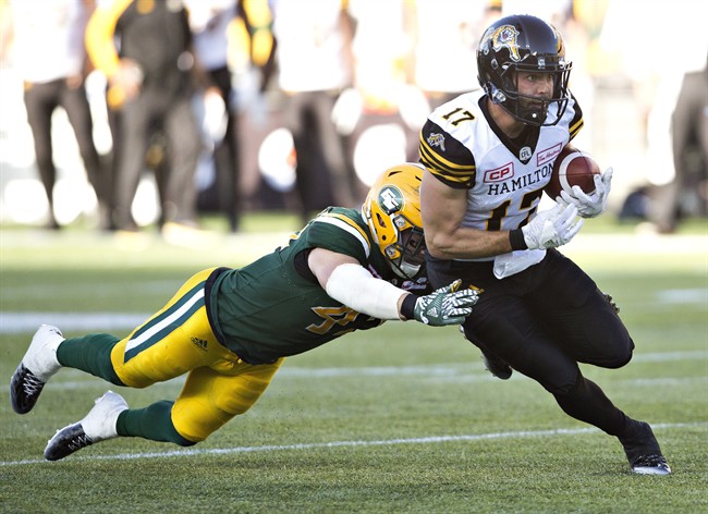 Hamilton Tiger-Cats' Luke Tasker (17) is tackled by Edmonton Eskimos' Tyler Thornton (42) during second half CFL action in Edmonton, Alta., on Saturday July 23, 2016.