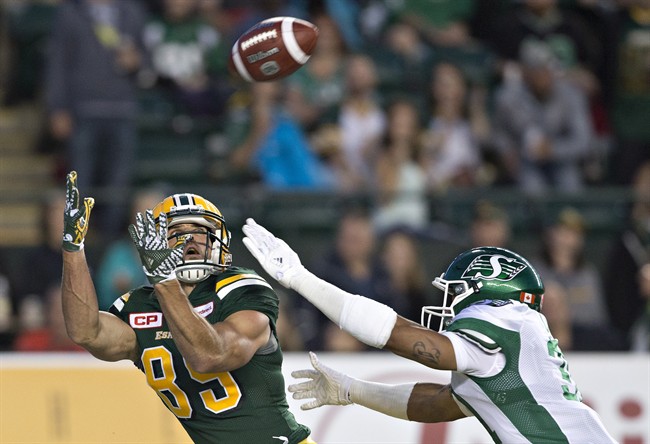 Saskatchewan Roughriders' Justin Cox (31) chases Edmonton Eskimos' Nate Coehoorn (85) as he tries to make the catch during second half action in Edmonton, Alta., on Friday July 8, 2016. 