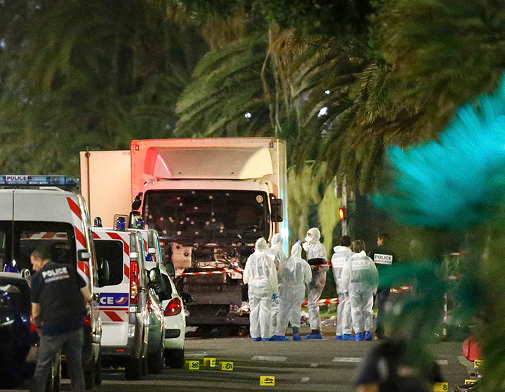 French police and forensic officers stand next to a truck July 15, 2016 that ran into a crowd celebrating the Bastille Day national holiday on the Promenade des Anglais killing at least 80 people in Nice, France.