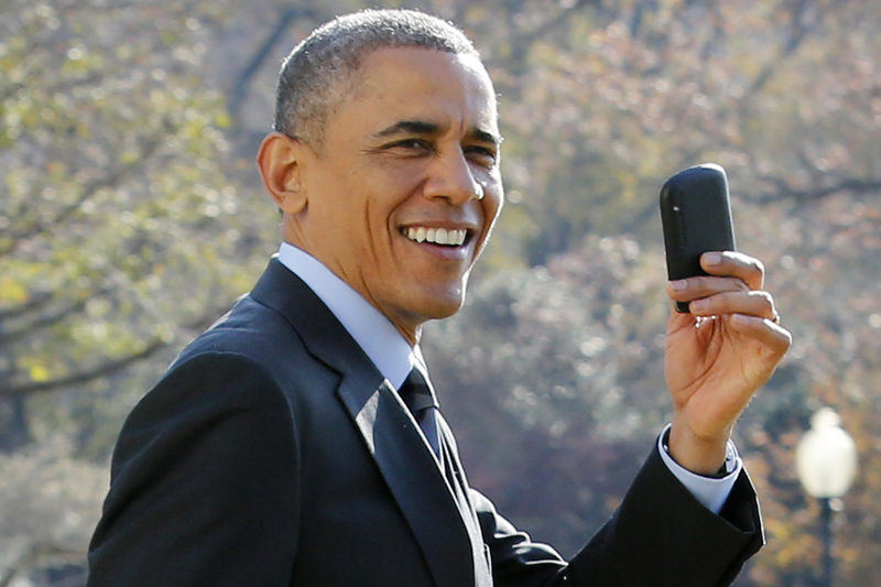 US President Barack Obama shows his Blackberry as he walks on the South Lawn of the White House in Washington, DC. 
