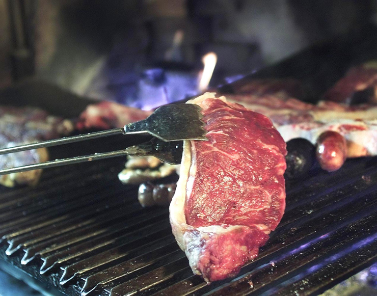 A succulent steak of Argentine beef sits atop a grill.