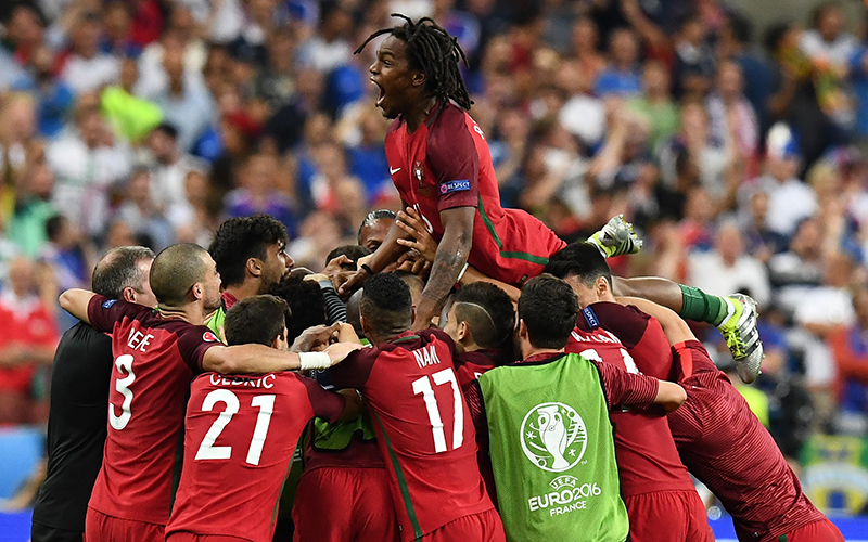 Portugal's midfielder Renato Sanches jumps on teammates after  Portugal's forward Eder scored the first goal of the match during the Euro 2016 final football match between France and Portugal at the Stade de France in Saint-Denis, north of Paris, on July 10, 2016.