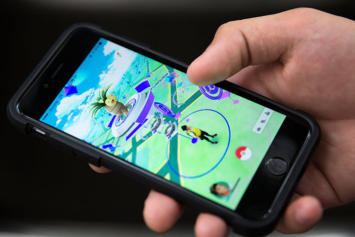 Police say a woman playing Pokemon Go in a parking lot north of Toronto was nearly hit by a driver who was also playing the wildly popular smartphone game.