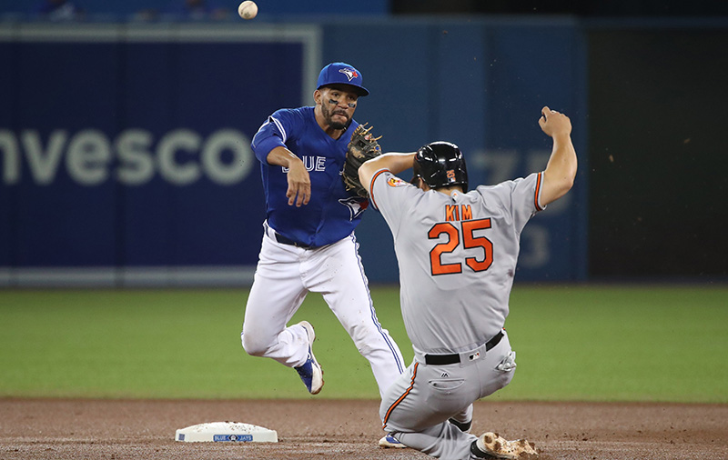 Devon Travis of the Toronto Blue Jays turns a double play in the fourth inning during MLB game action as Hyun Soo Kim of the Baltimore Orioles slides into second base on July 31, 2016 at Rogers Centre in Toronto.