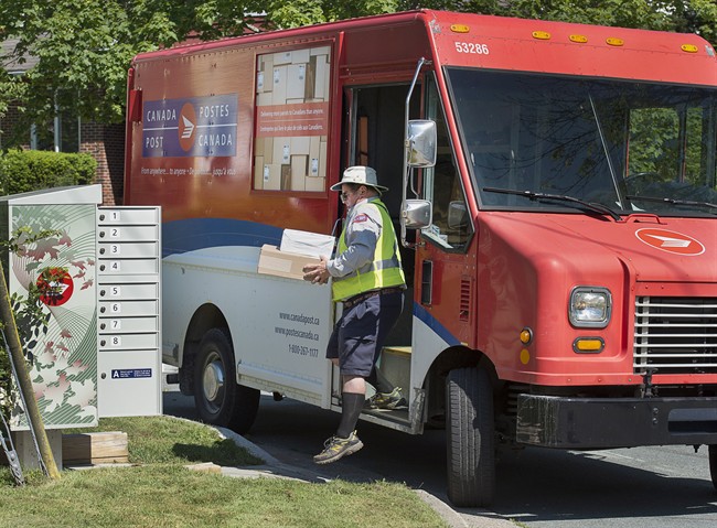 A Canada Post employee fills a community mail box in Dartmouth, N.S. on Thursday, June 30, 2016. 