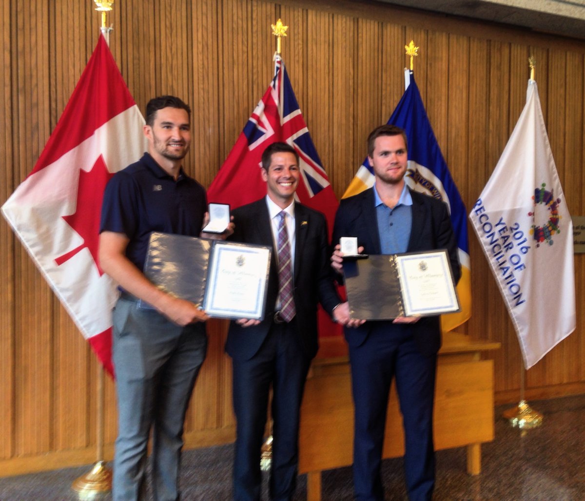 Mark Stone (left) and Calvin Pickard (right) post with Mayor Brian Bowman, after receiving their sports excellence awards .