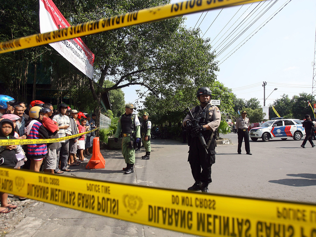 Indonesian police officers stand guard after a suicide bomb attack at the Police Headquarters in Solo, Central Java, Indonesia.