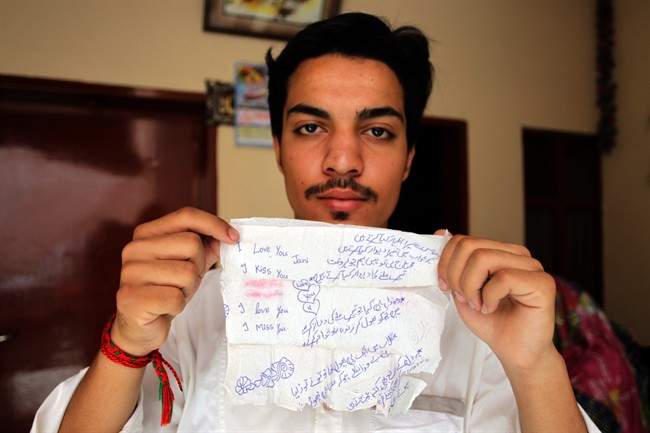 In this June 11, 2016 photo, Hassan Khan shows a tissue on which his wife Zeenat wrote a poem and messages to him, in Lahore, Pakistan.