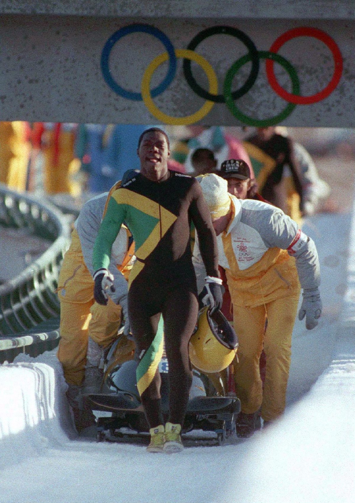 Members of the Jamaican four-man bobsled team walk up the course after wiping out during a run at the 1988 Winter Olympics in Calgary, Dec. 23, 1988. 