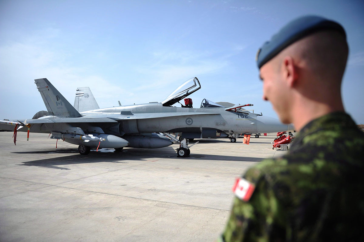 A Canadian soldier looks at a CF-18 as it sits loaded for flight at Camp Fortin on the Trapani-Birgi Air Force Base in Trapani, Italy, on Thursday, September 1, 2011.
