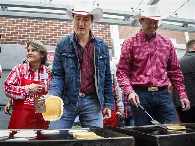 Prime Minister Justin Trudeau, centre, flips flapjacks at a Stampede breakfast in Calgary, Alta., Saturday, July 16, 2016.