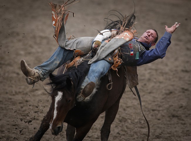 In this July 2016 file photo, Yvan Jayne, from Marseille, France, stays on True Grit during bareback rodeo semi-final action at the Calgary Stampede in Calgary, Alta., An urban rodeo planned for Montreal will go ahead after legal proceedings against NomadFest were dropped. Thursday, June 8, 2017.