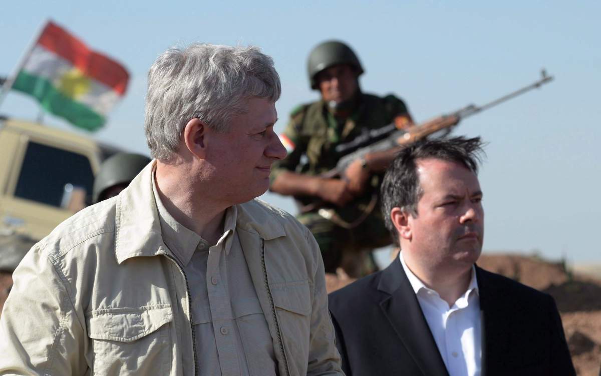 A Kurdish soldier sits in the background as former Prime Minister Stephen Harper and former Minister of Defence Jason Kenney visit members of the Advise and Assist mission, approximately 6 kilometres from active ISIL fighting positions, near Erbil, Iraq, on Saturday, May 2, 2015.