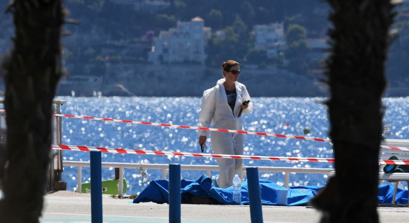 A forensic expert examines dead bodies covered with a blue sheet on the Promenade des Anglais seafront in the French Riviera city of Nice on July 15, 2016 (BORIS HORVAT/AFP/Getty Images)