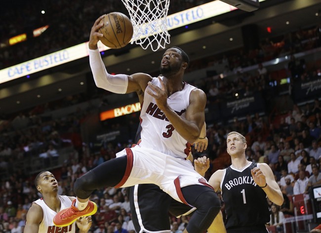 Miami Heat guard Dwyane Wade (3) shoots in front of Brooklyn Nets center Mason Plumlee (1) during the first half of an NBA basketball game in Miami. 