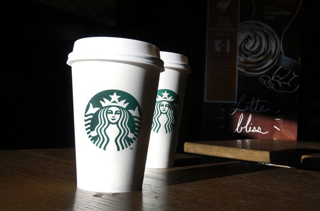  In this this Friday, Jan. 17, 2014, file photo, Starbucks cups are shown mugs in a cafe in North Andover, Mass. Starbucks announced July 12, 2016, that it was raising prices slightly on brewed coffee, espresso and tea lattes in U.S. company-operated stores.