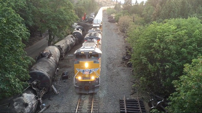 FILE - This June 6, 2016, file aerial video image taken from a drone shows crumpled oil tankers lying beside the railroad tracks after a fiery June 3 train derailment that prompted evacuations from the tiny Columbia River Gorge town of Mosier, Ore. 