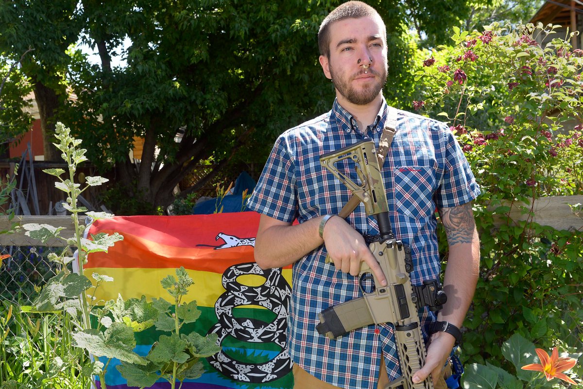 Matt Schlentz poses with his Rainbow-Gadsen Flag and AR-15 in his backyard in Salt Lake City,  Wednesday, June 16.  