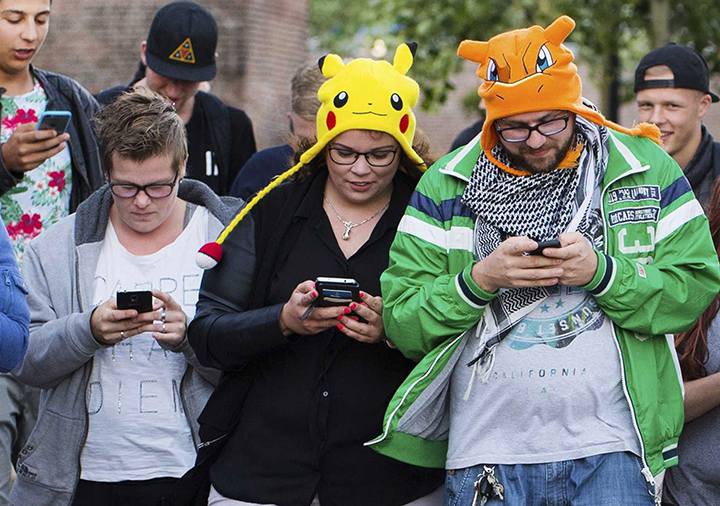 People playing the new game Pokemon Go on their smartphones. The new craze has taken over the streets of Winnipeg, prompting police to release safety warnings.