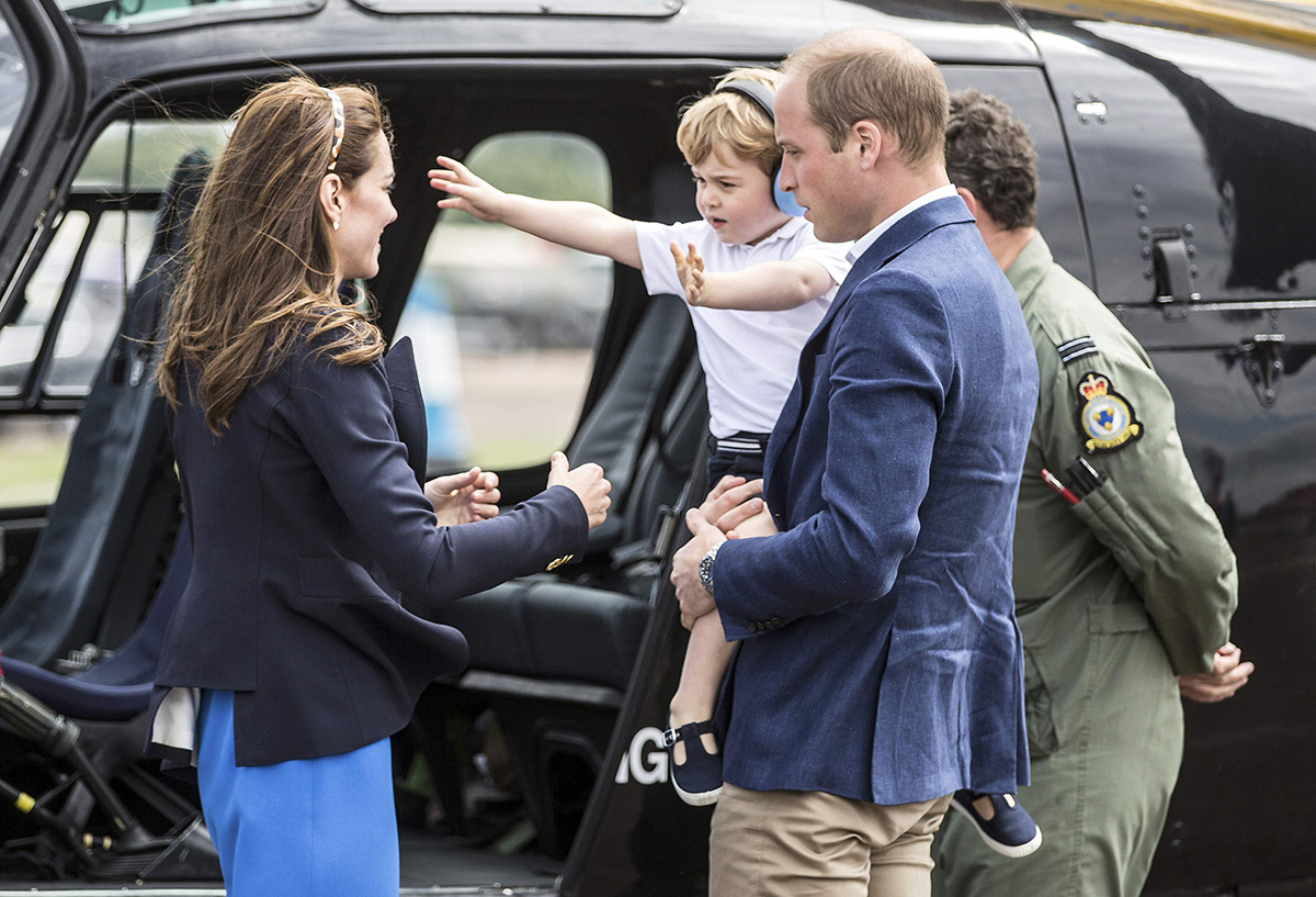 Prince George beckons for his mother after being lifted out of a Squirrel helicopter similar to the one that his father Prince william trained on as he visits the Royal international air tattoo at RAF Fairford, Britain July 8, 2016.  