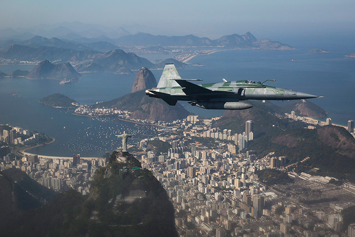 A F-5 fighter flies over the Christ the Redeemer statue while intercepting another aircraft during a Brazilian Air Force presentation for the press ahead of the Olympic games in Rio de Janeiro, Brazil, Thursday, July 14, 2016. 