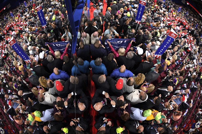 Delegates on the floor of the convention are reflected in a mirror on the side of a camera stand during the second day of the Republican National Convention in Cleveland, Tuesday, July 19, 2016. 