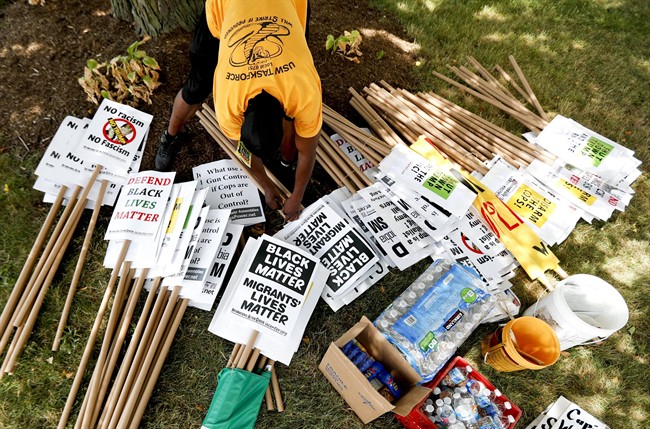 A demonstrator organizes protest signs, Sunday, July 17, 2016, in Cleveland, in preparation for the Republican National Convention that starts Monday. 