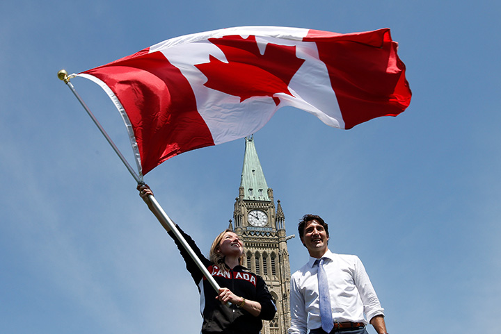 Gymnast Rosie MacLennan waves the Canadian flag next to Prime Minister Justin Trudeau on July 21, 2016.