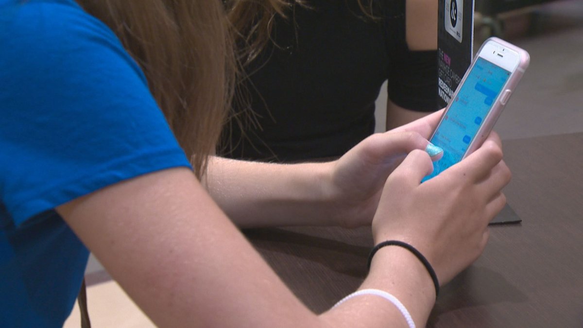 A student uses her smartphone in Edmonton. 