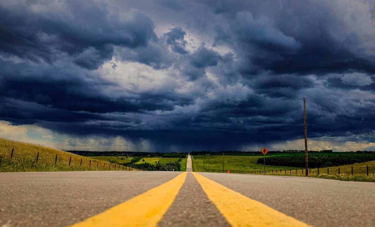 Storm clouds build over a highway in southern Alberta near the town of Carstairs on Monday, July 4, 2016.