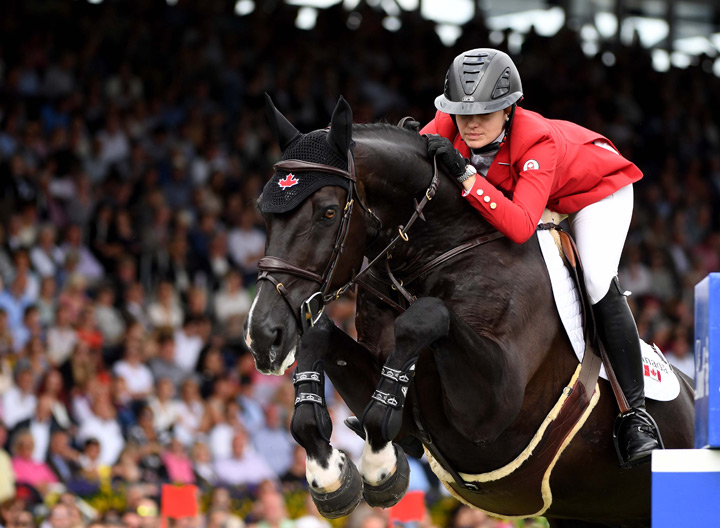 Tiffany Foster of Canada jumps with her horse Tripple X III