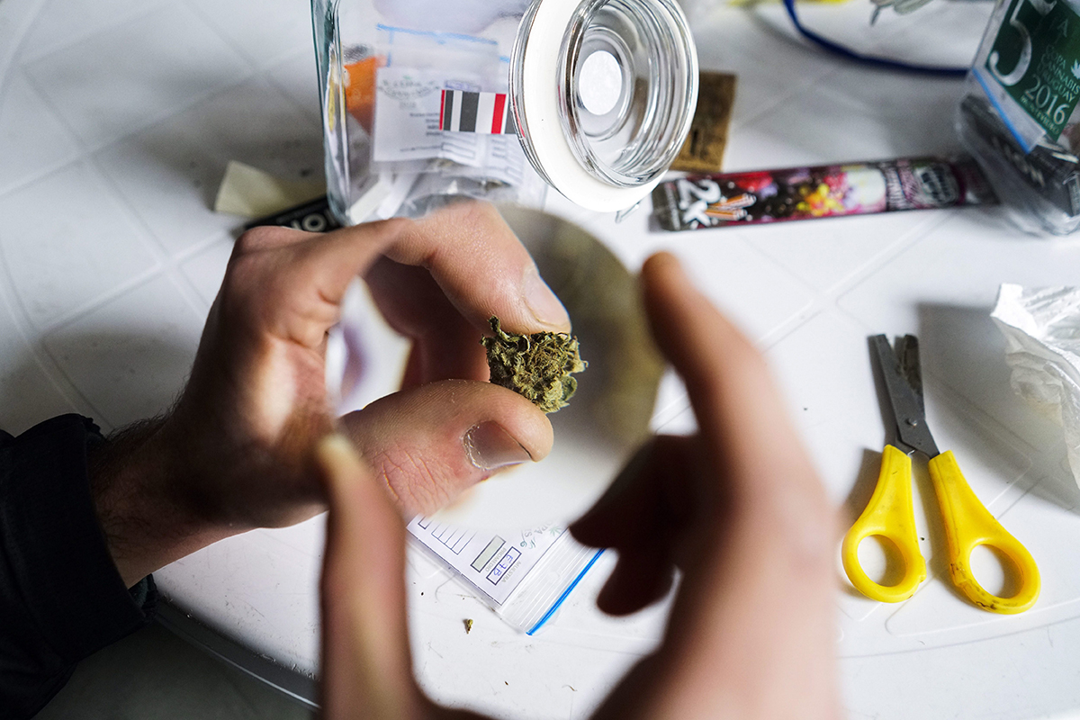 In this July 16, 2016 photo, a competitor looks at a marijuana bud through a magnifying glass at the fifth annual Cannabis Cup, a competition for best marijuana, in Montevideo, Uruguay.