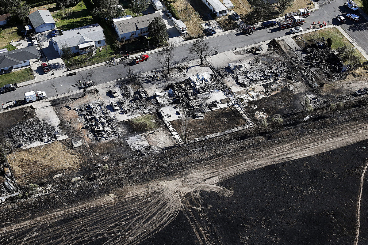 This aerial photo shows the charred remains of homes following a fire in Tooele, Utah on Wednesday, July 20, 2016. Firefighters contained a blaze fueled by wind that ripped through a Utah trailer park, displacing dozens of people and destroying multiple homes.