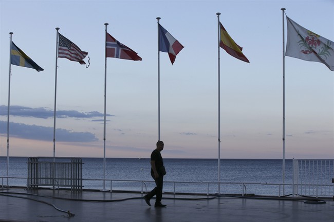 A security guard walks near the scene of an attack after a truck drove onto the sidewalk and plowed through a crowd of revelers who'd gathered to watch the fireworks in the French resort city of Nice, southern France, Friday, July 15, 2016.