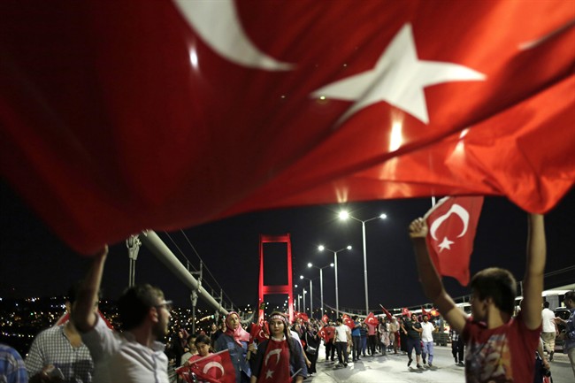 Pro-government supporters wave a Turkish flag as they protest on Istanbul's iconic Bosporus Bridge, late Thursday, July 21, 2016. Turkish lawmakers approved a three-month state of emergency, endorsing new powers for Turkey's President Recep Tayyip Erdogan that would allow him to expand a crackdown that has already included mass arrests and the closure of hundreds of schools, in the wake of the July 15 failed coup.
