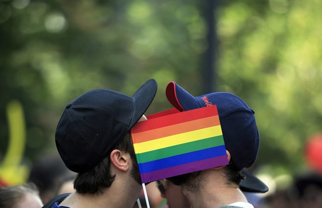 Men cover their faces with rainbow flags during a gay pride parade in Bucharest, Romania. 
