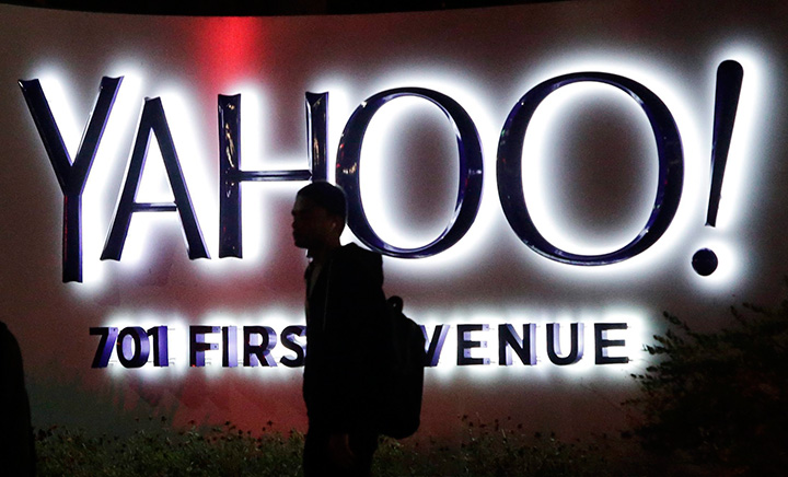 In this Nov. 5, 2014, file photo, a person walks in front of a Yahoo sign at the company's headquarters in Sunnyvale, Calif. 