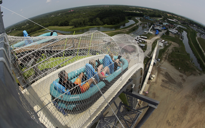 In this photo taken with the fisheye lens, riders go down the world's tallest water slide called "Verruckt" at Schlitterbahn Waterpark, Wednesday, July 9, 2014, in Kansas City, Kan. The ride will be dismantled following all investigations into the death of a young boy who died on the slide.
