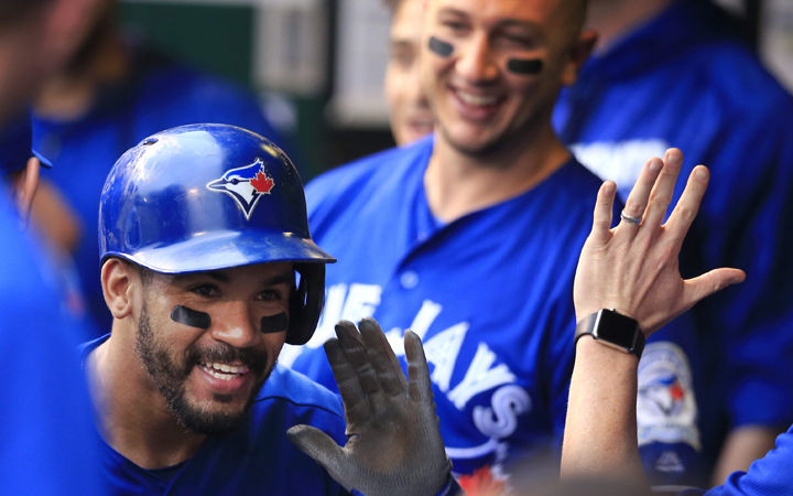 Toronto Blue Jays' Devon Travis celebrates with teammates after his solo home run off Kansas City Royals relief pitcher Dillon Gee during the first inning of a baseball game at Kauffman Stadium in Kansas City, Mo., Friday, Aug. 5, 2016. 