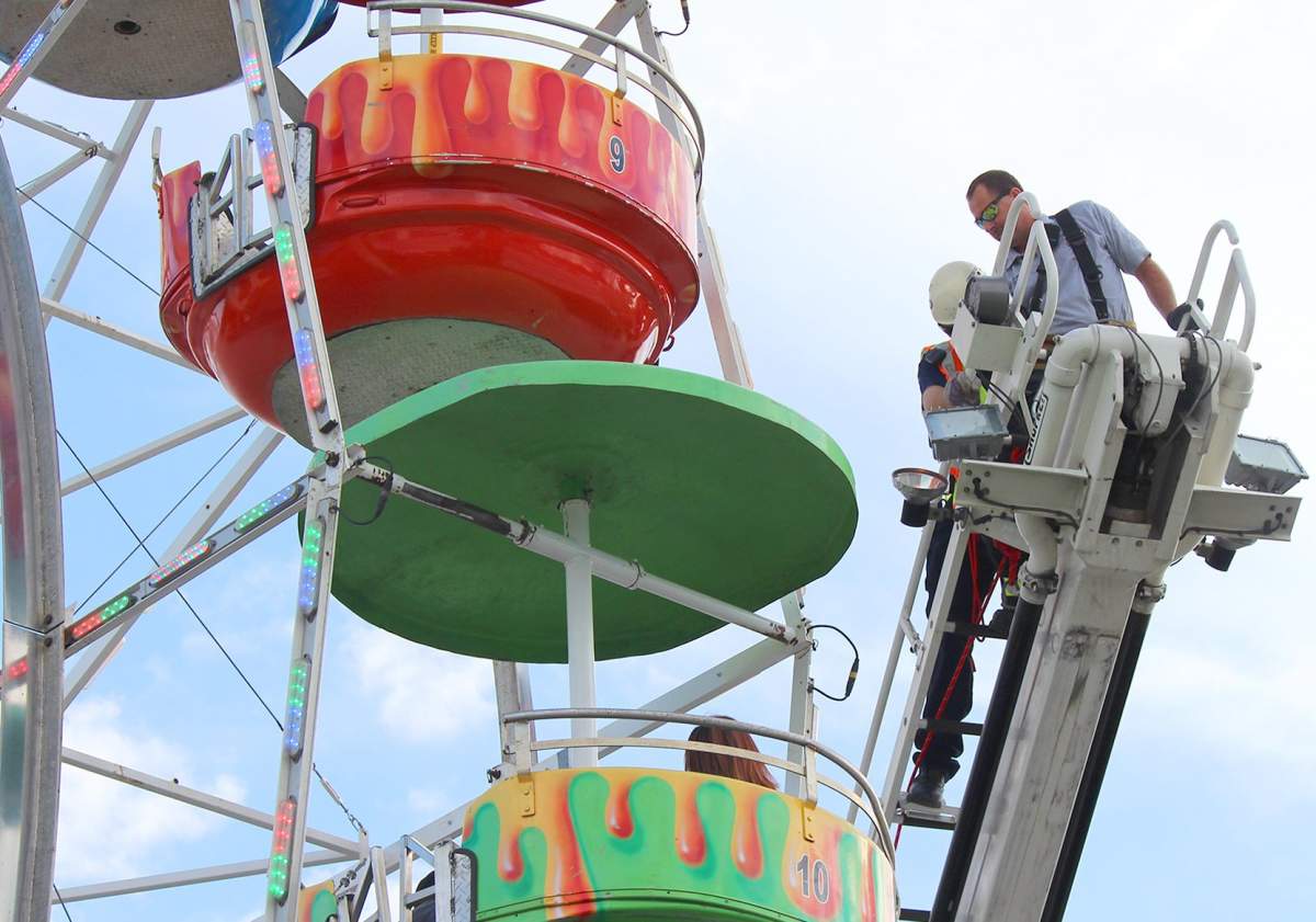 Members of the Greeneville Fire Department help people off the ferris wheel at the Greene County Fair in Greeneville, Tenn., Monday, Aug. 8, 2016. A few people who fell 30 to 45 feet from a Ferris wheel in Tennessee were responsive and answering questions Monday night, police said.