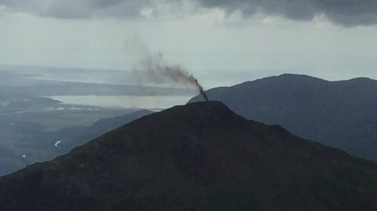 In this image provided by The National Trust, a thick plume of smoke rises from Yr Aran after a helicopter made an emergency landing in north Wales, Tuesday Aug. 9, 2016.  
