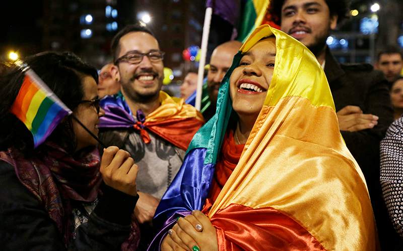 People celebrate in a park as they listen to the announcement from Havana, Cuba, that delegates of Colombia's government and leaders of the Revolutionary Armed Forces of Colombia reached a peace accord to end their half-century civil war, in Bogota, Colombia.