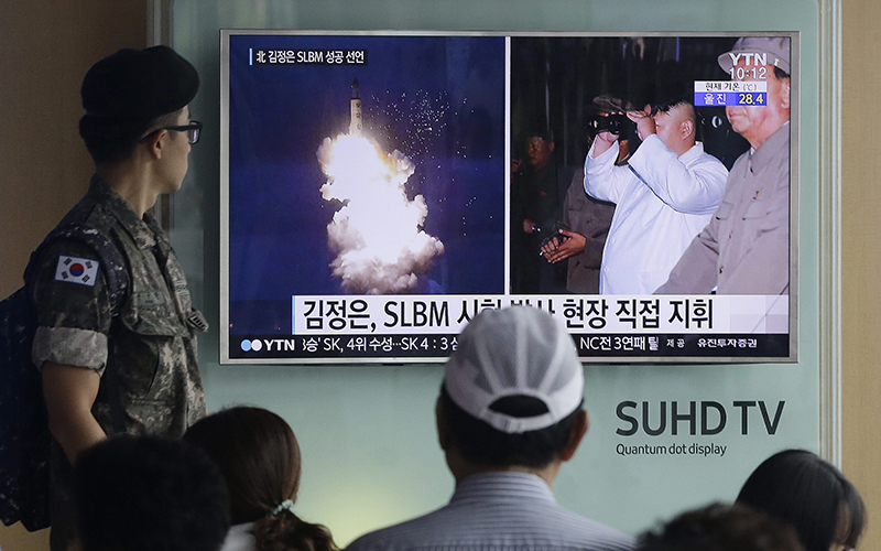 A South Korean army soldier watches a TV news program showing images published Thursday in North Korea's Rodong Sinmun newspaper of North Korea's ballistic missile believed to have been launched from underwater and North Korean leader Kim Jong-un, at Seoul Railway station in Seoul, South Korea, Thursday, Aug. 25, 2016. 