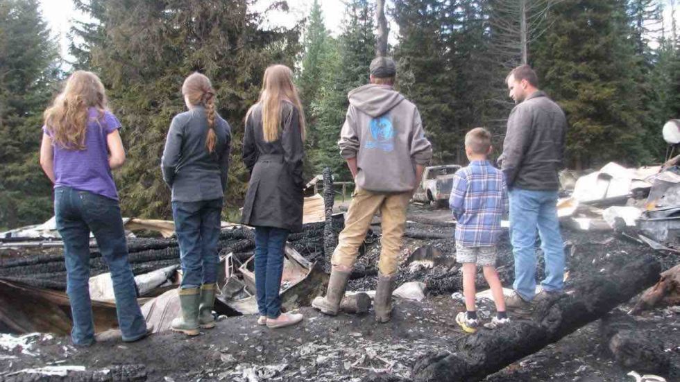 The Duits family surveys the wreckage of their family home after a fire at their home near 100 Mile House. 
