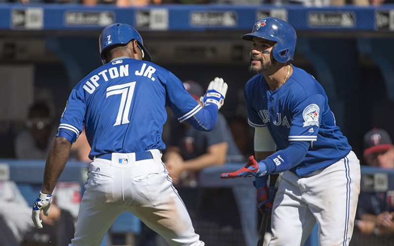 Toronto Blue Jays left fielder Melvin Upton Jr. celebrates with second baseman Devon Travis after scoring a run during the eighth inning in a game against the Minnesota Twins at Rogers Centre on Sat. Aug. 27, 2016.